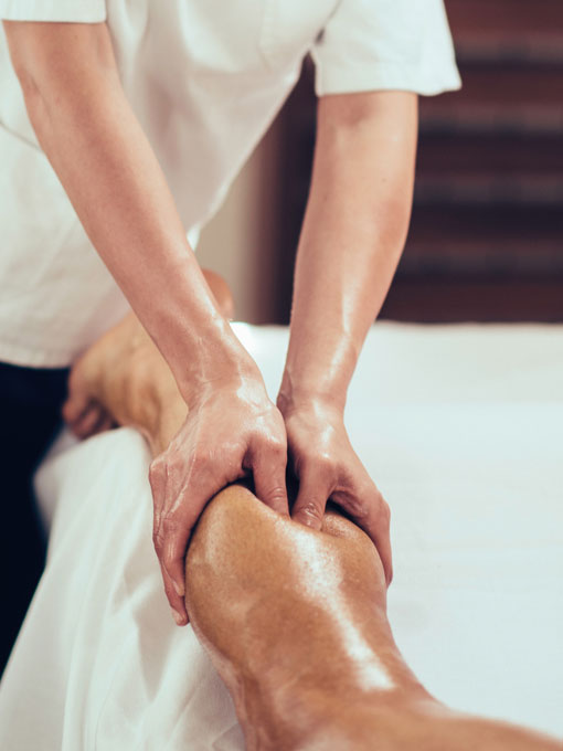 Physical therapist massaging athlete's leg.